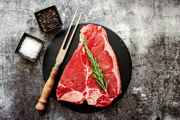 raw T-bone steak on stone background with copy space for your text