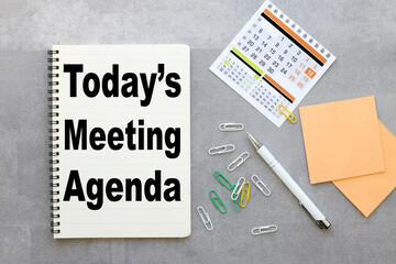 Today's meeting Agenda. gray background with notepad and calendar .text on paper