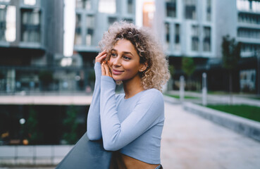 Positive woman leaning on railing and looking away