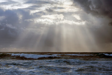 Cloudy seascape with sunbeams