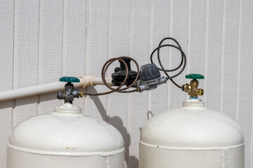 A gas regulator on two propane tanks