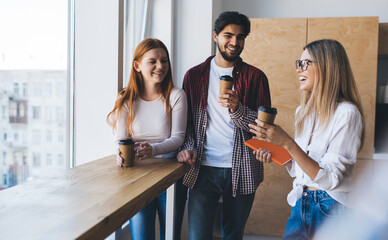 Cheerful group of colleagues standing with coffee