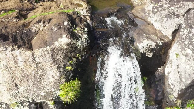 Picturesque flying over the mountain creek fall down from steep high cliff to wide valley. Cascade 500 Pieds waterfall on Mauricius island in Indian ocean.