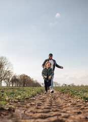 Fototapeta premium Father and son playing outdoors in spring