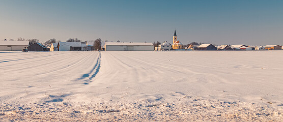 Winter landscape on a sunny day with a church near Schambach, Bavaria, Germany