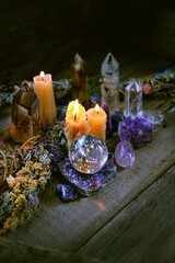 Candles, gemstones, floral cleansing bundles on wooden rustic table, dark background. healing Crystal ritual, Witchcraft, Esoteric spiritual practice. wiccan magic for relax, meditation. witch altar.
