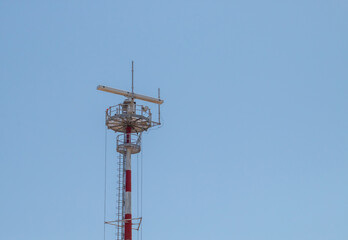 Antena de telecomunicaciones situada en el cabo de Palascia, Otranto, Italia. Moderno y potente equipo de telecomunicaciones situado al final de un largo poste rojo y blanco.