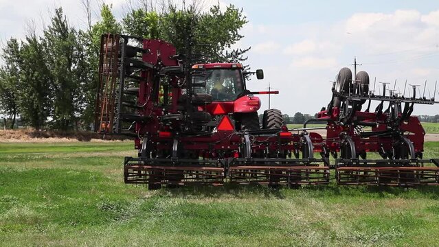 Towed equipment on tractor, modern cultivator and harrow. Demonstration of agricultural equipment operation