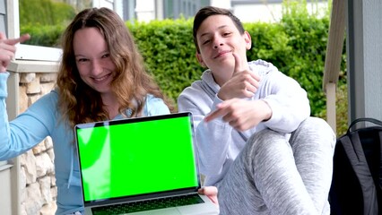popular cool photo of teens holding laptop green edge chroma key boy and girl showing fingers ad laughing sincere smile shoulder backpack online learning teen life happy end fun entertainment games