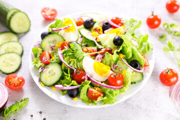 healthy vegetable salad with fresh lettuce,  tomato, cucumber and egg- diet food, healthy eating concept