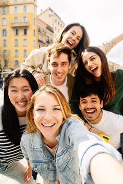 Vertical Photo Of Young Group Of Happy People Taking Selfie Enjoying Time Together. Multiracial Student Friends Laughing At Mobile Phone Camera Photo.