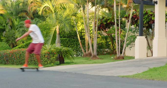 Skateboarder in headphones rides on skateboard at street surf style. 
