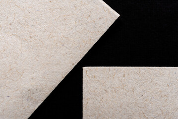Primer plano de papel ecológico reciclable formando figuras geométricas aislado sobre fondo negro. Textura de papel. Papel vintage. Detalles. Polvo y pelusa.