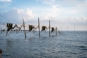 Silhouette of fishermen pulling a nets on fishing poles at sea in Tra Vinh province, Vietnam, Asia during sunrise, local people call it is Day hang khoi.