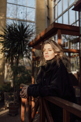 Plant-loving woman is enjoying the moment in a greenhouse surrounded by plants.