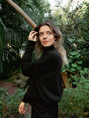 Young beautiful woman in botanical garden. There is plenty of green plants.