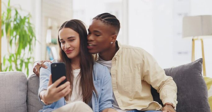 Peace sign, selfie and couple kiss in home, sofa and taking profile picture for happy memory. Funny, interracial and black man and woman with tongue out, kissing cheek and v emoji for social media.