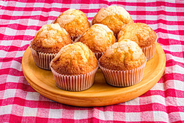 Freshly baked muffins on wooden board