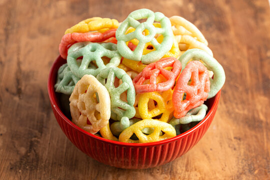 Bowl of Cooked Colorful Rainbow Wheel Fryums on a Wooden Table