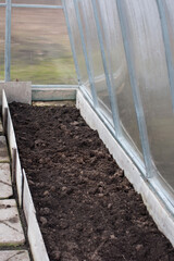 dug up beds in the greenhouse. Preparation of the soil for sowing seedlings, gardening concept
