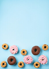 Obraz premium Donuts Doughnuts with Chocolate, Pink Marshmallow and Sugar Sprinkles on Blue Background