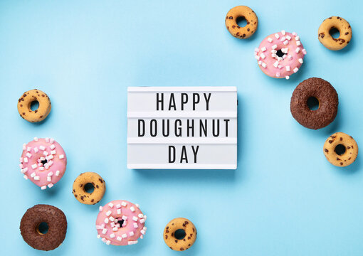 Donuts Doughnuts with Chocolate, Pink Marshmallow and Sugar Sprinkles on Blue Background