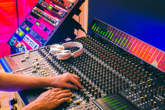 sound engineer hands mixing music on audio mixing console in home studio