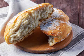 Homemade ciabatta bread with whole grain flour on a wooden background. Rustic style.