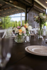 A very nicely decorated wedding table appointments with beautiful decor with plates and serviettes in spring garden. Beautiful flowers on table in wedding day. The elegant dinner table.