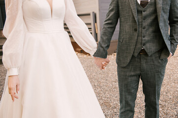 The bride and groom hold hands