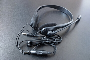Hands free headphones on black table.