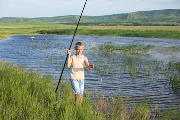 Hobby and leisure activities during summer holidays. Little Caucasian boy at fishing during the summer holidays