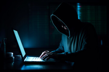 Hacker with black hoodie is making a cybercrime