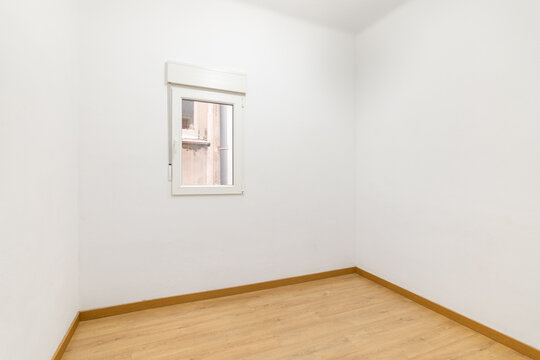 Small compact room with a small window and white walls, waiting for furniture and owners. The concept of buying budget housing in a mortgage. Copyspace
