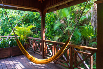yelllow hammock on a patio at a resort in the tropics