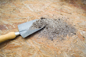 Cuchara de jardín con tierra para plantar, textura de madera. instrumento de jardinería 
