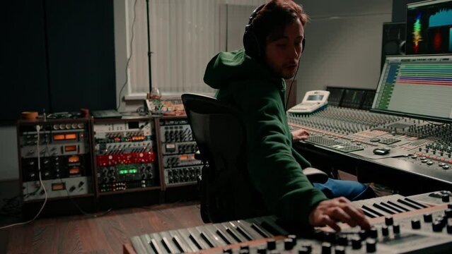 Male hands play electronic piano keyboard Fingers tap keys midi controller Musician produces song in recording studio