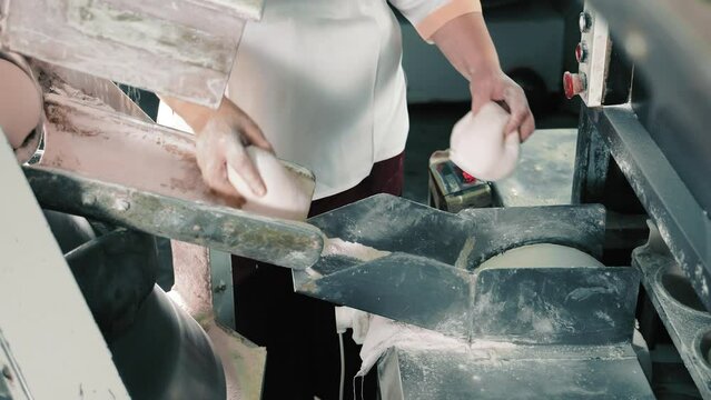 Bread production line. The baker controls the bread making process. Selection and weighing of dough.