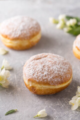 Berliner donuts in powdered sugar with jasmine flowers