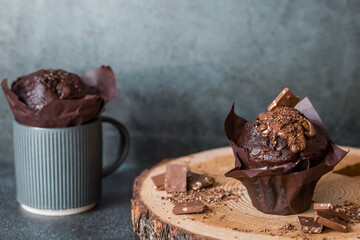 Delicious freshly baked chocolate muffins on a dark background. Delicious cupcake close-up. The context of a bakery with pastries. Confectionery products.
