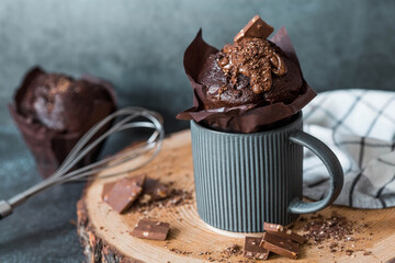 Delicious freshly baked chocolate muffins on a dark background. Delicious cupcake close-up. The context of a bakery with pastries. Confectionery products.
