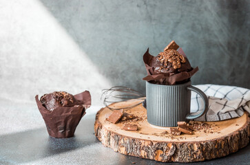 Delicious freshly baked chocolate muffins on a dark background. Delicious cupcake close-up. The context of a bakery with pastries. Confectionery products.