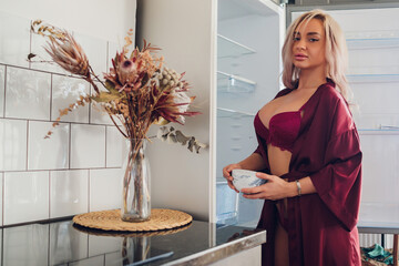 Portrait of a woman in lingerie posing in the kitchen.