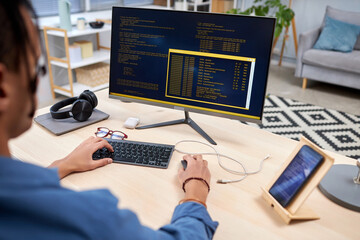 High angle view at young IT programmer writing code for mobile devices at home office workplace