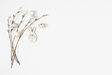 Easter trendy composition. willow plant branches, easter eggs and bunny on white background. Minimal concept Easter. Flat lay, top view, copy space