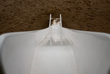 white slide top shot , white slide in children's playground on sand background , falling concept