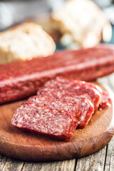 Smoked .sausage. Sliced salami on cutting board.
