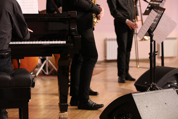 A group of musicians playing piano and brass instruments jazz stand on the stage