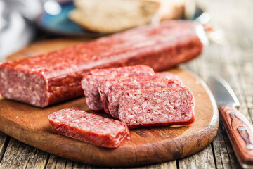 Smoked .sausage. Sliced salami on cutting board.