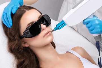 Removal of permanent makeup on the eyebrows of a woman.Carbon face peeling in a beauty salon....